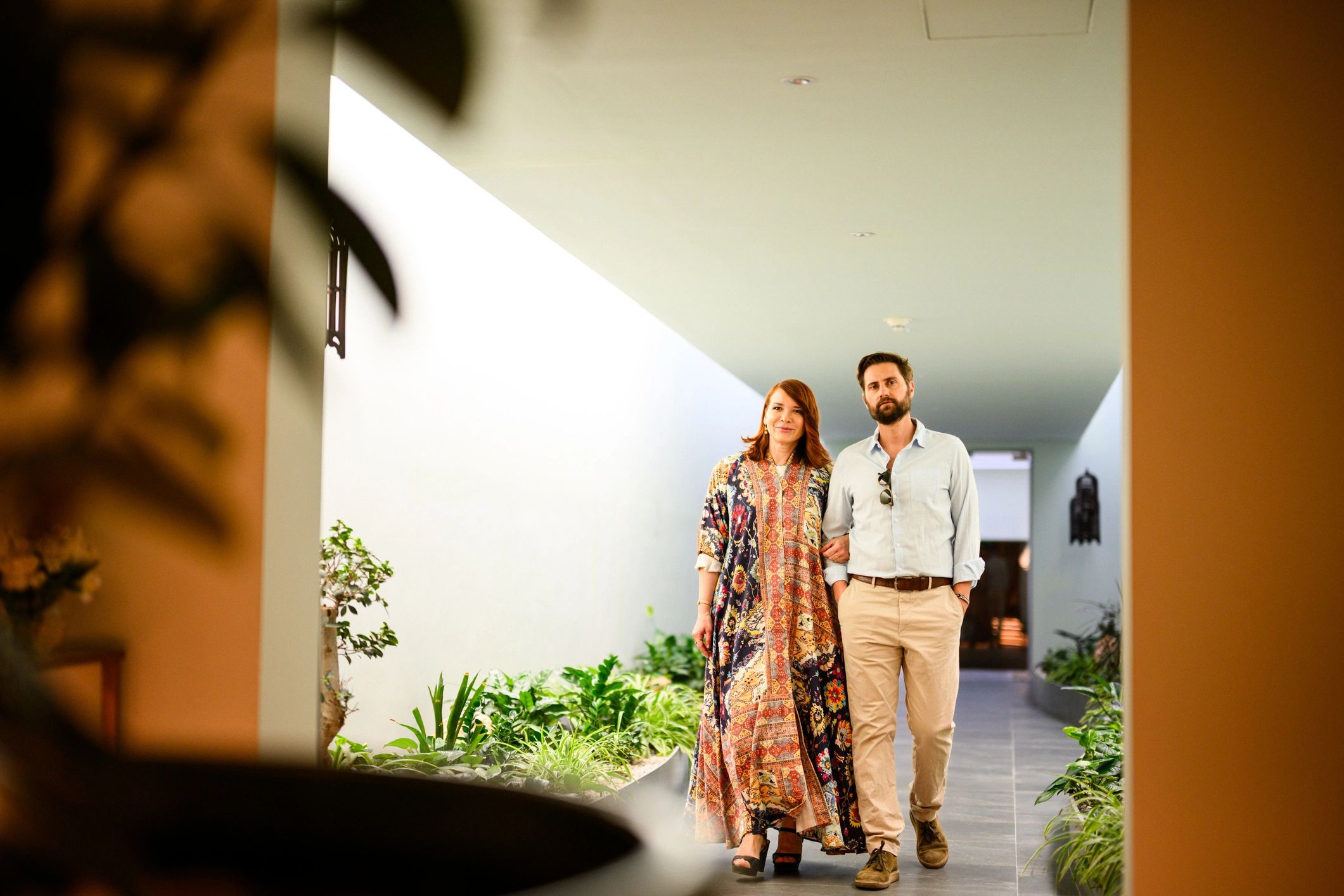 Traveler couple walking through a modern luxury hotel corridor