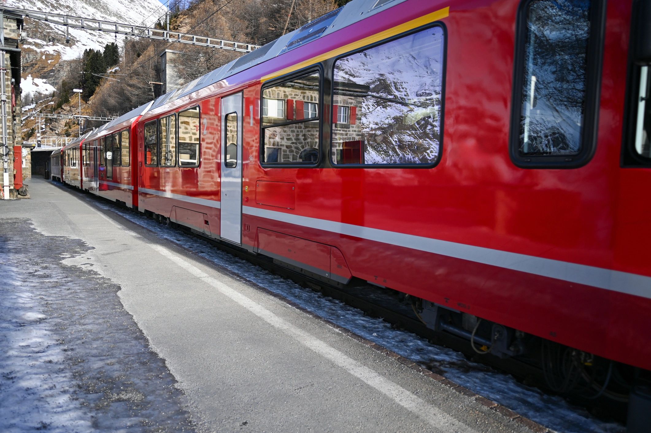 Red train at mountain station in the Alps