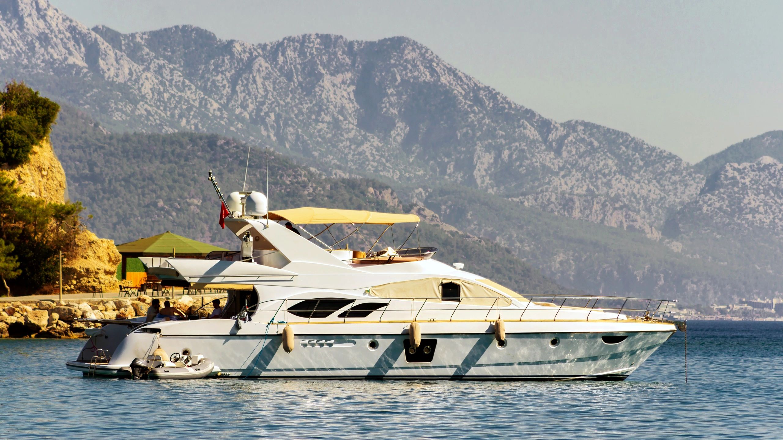 Luxury yacht on calm blue sea with mountains
