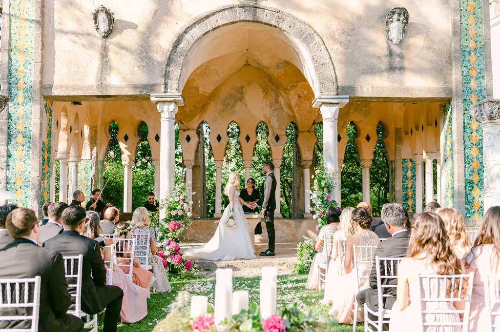 Outdoor wedding ceremony under ornate stone pavilion