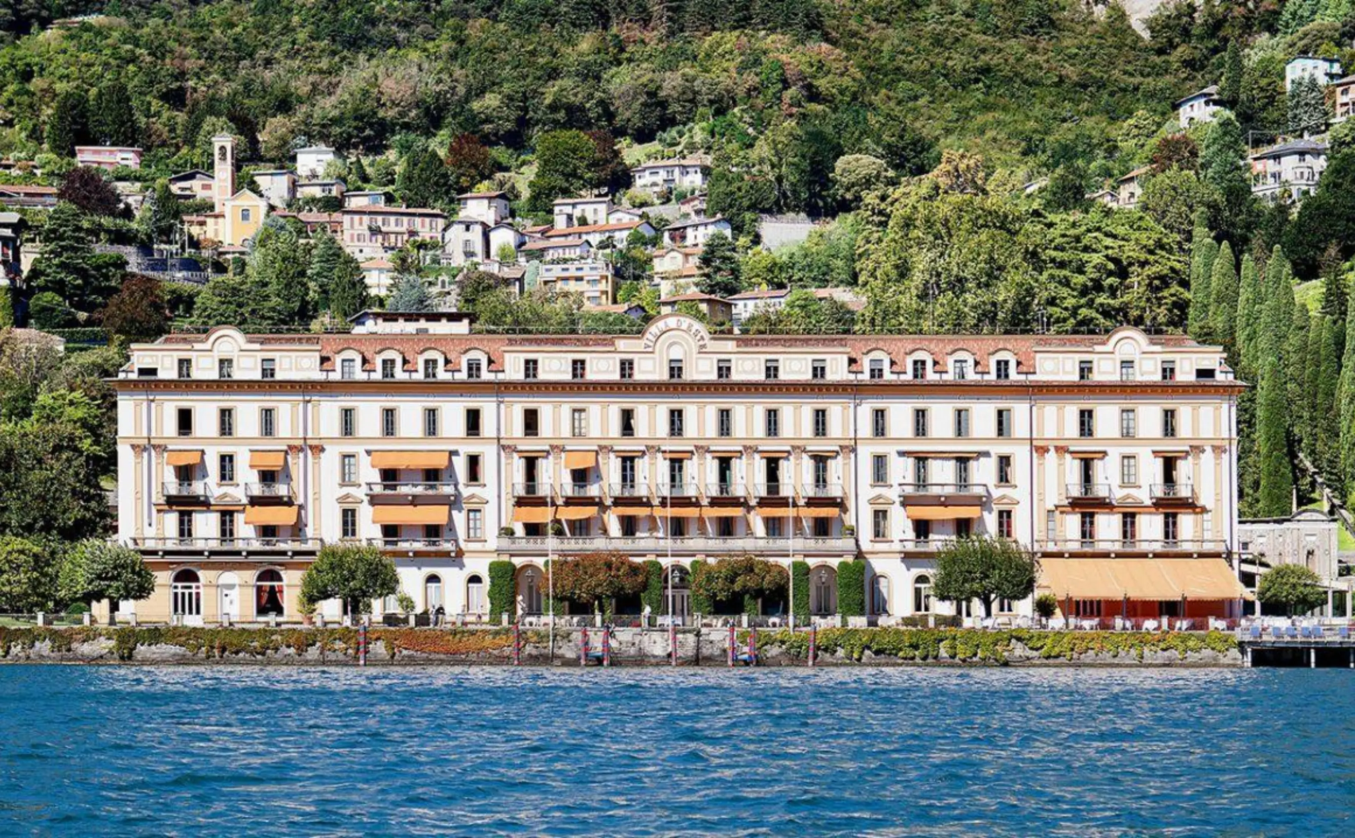 Grand lakeside hotel with hillside village backdrop